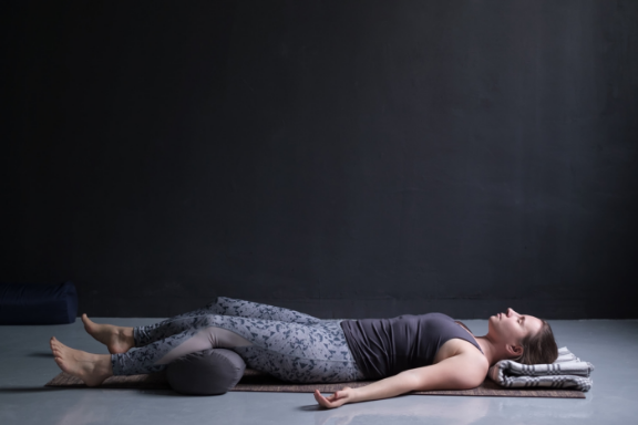 Woman practicing supported savasana