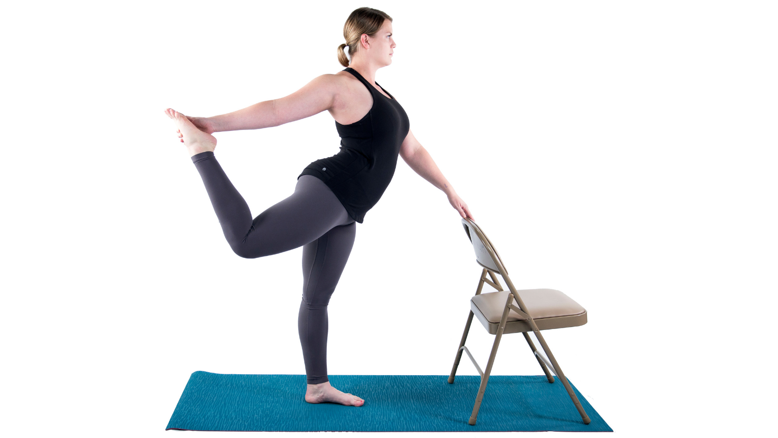 Yoga student practicing Natarajasana or Dancer's Pose with a chair as a prop