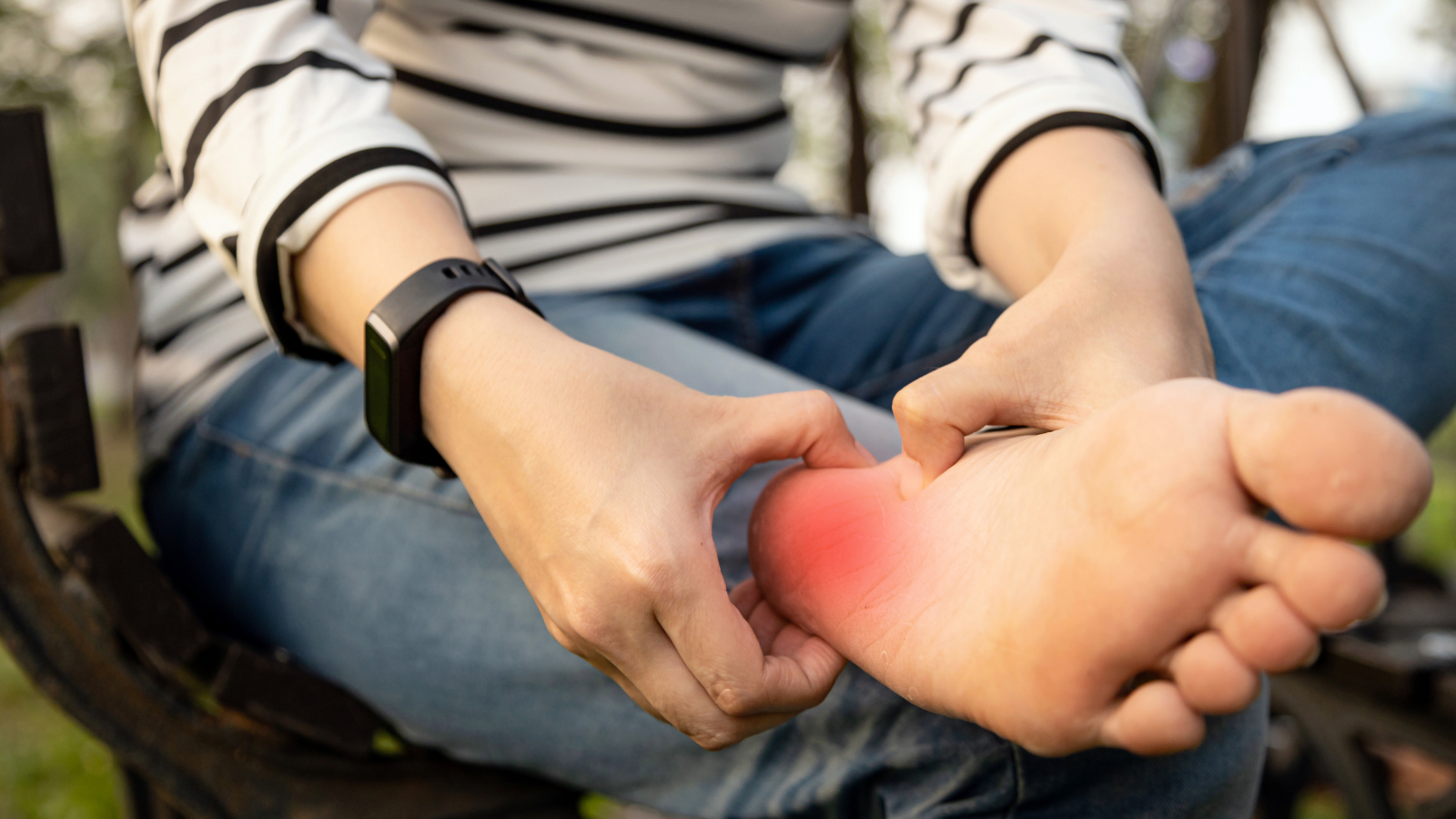 Plantar fasciitis, young woman holding her feet and massaging with her hand suffering from tendon inflammation