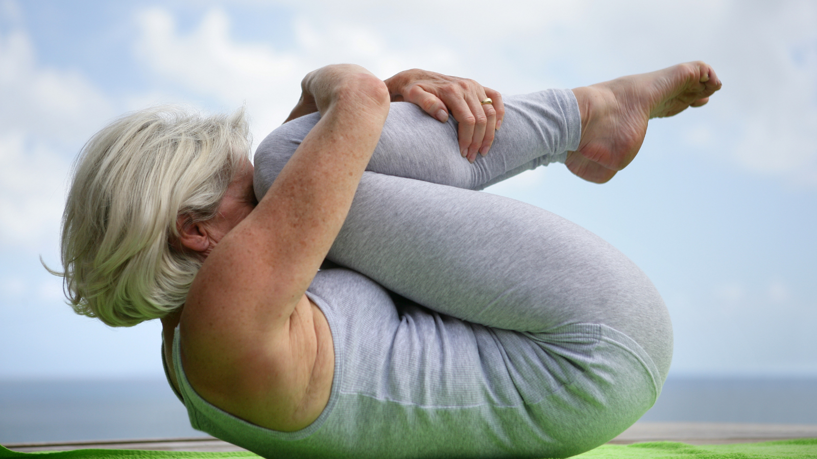 Woman holding a yoga position- curled up and protective