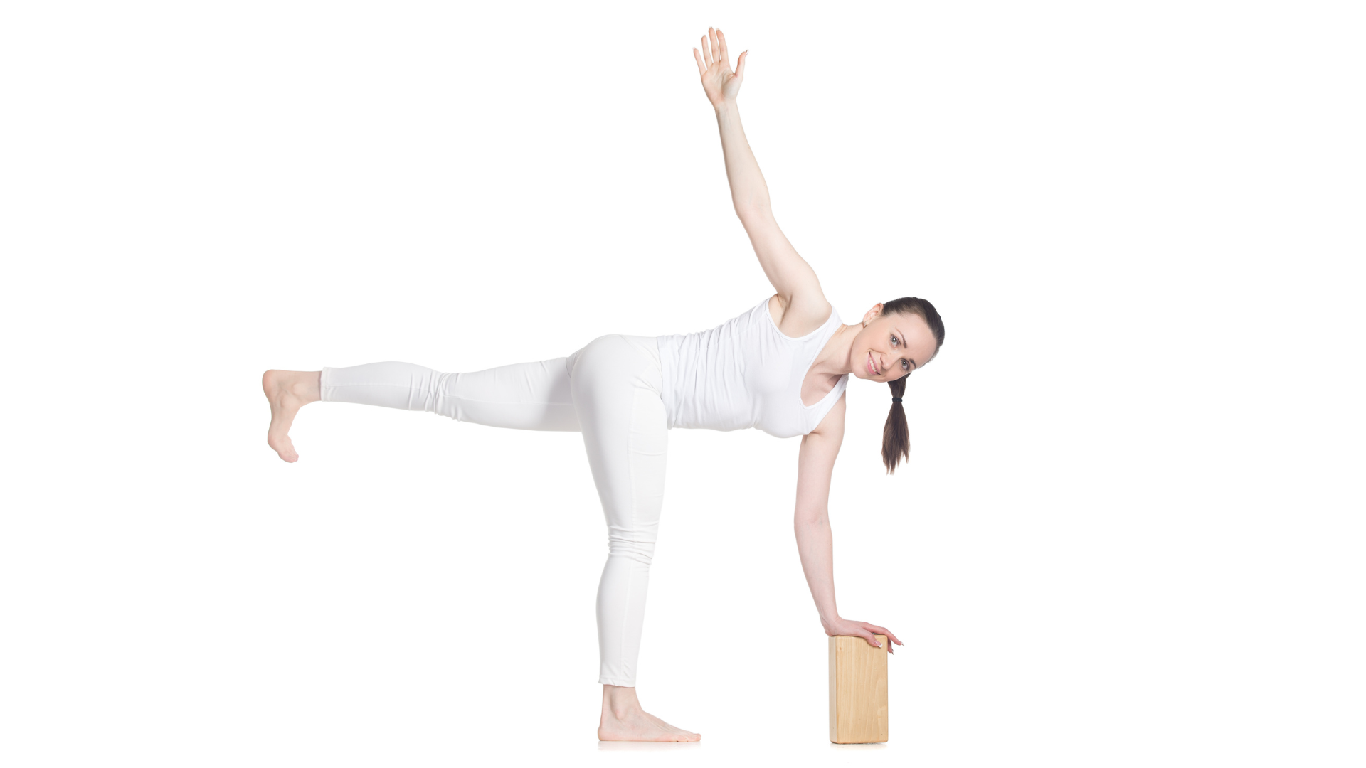 Sporty young cheerful  yoga student practicing in Parivrtta Ardha Chandrasana (Revolved Half Moon) representing yoga as a way to manage holiday stress.