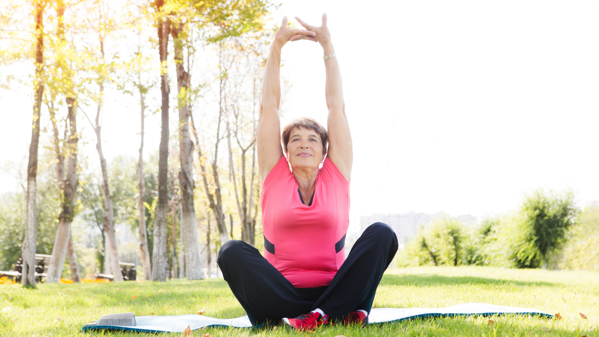 Woman practicing yoga outdoors in a park.