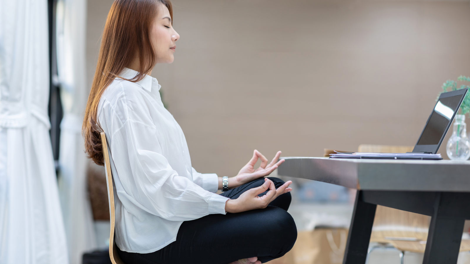 Woman doing yoga in office relaxes after working hard feeling happiness and comfortable.