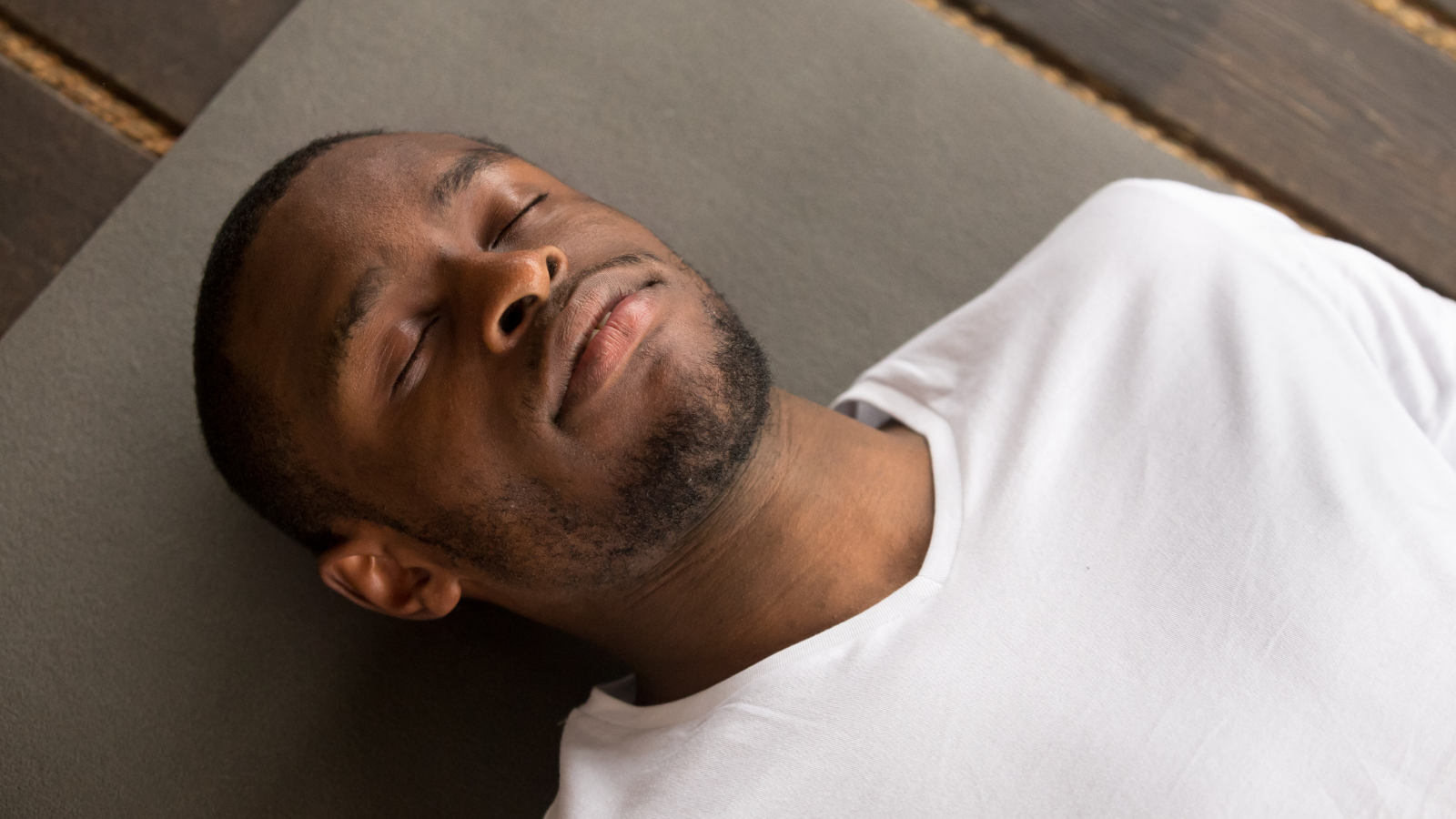 Photo of young black man lying in Corpse Pose or Savasana Pose