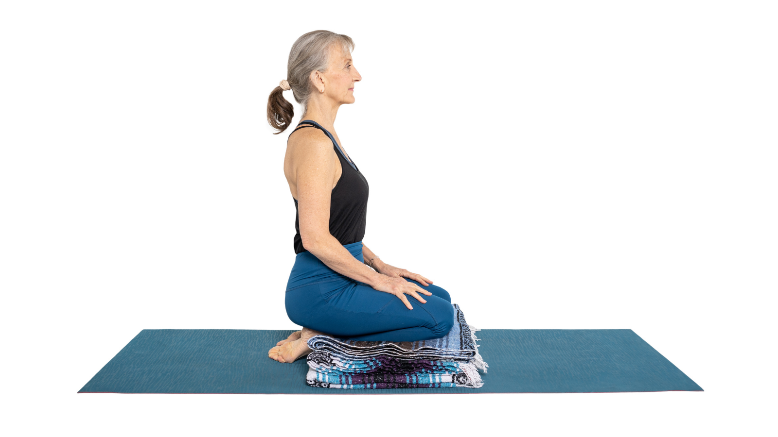 Woman sitting in Hero's Pose or Virasana to work on facial exercises to help with TMJ pain