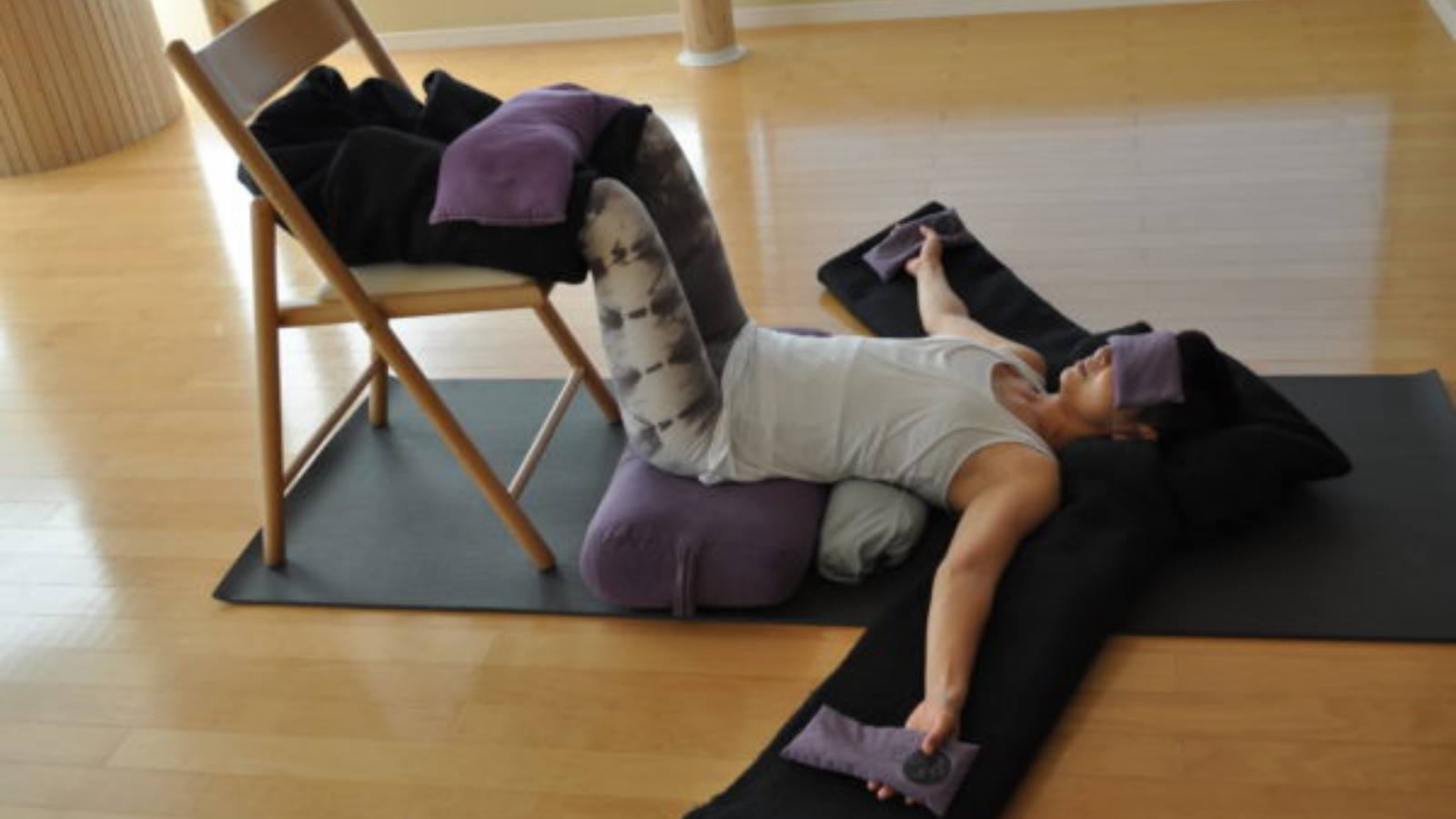 Restorative Instant Maui Pose with a sand bag added for a variation of the pose.