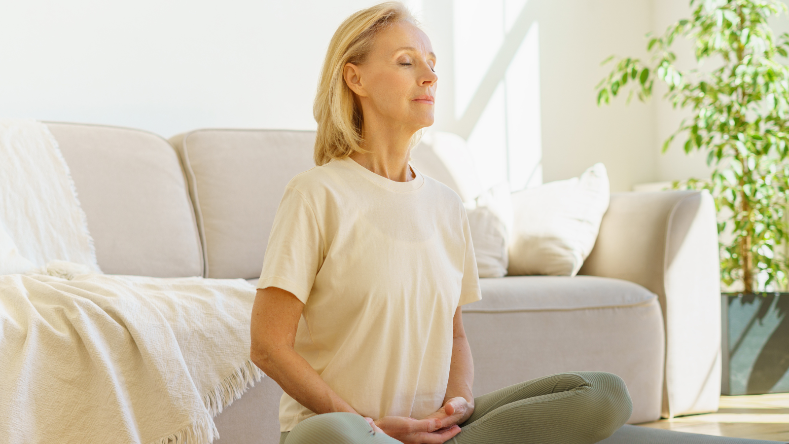 Peaceful senior woman in Lotus Pose practicing meditation and breathwork