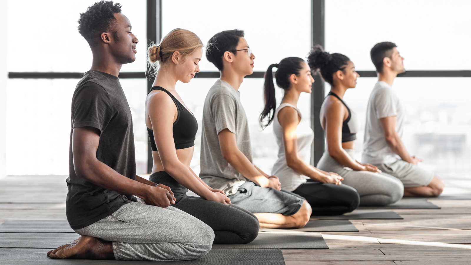 Yoga students at the end of class experiencing the positive effects of saying and meaning the word "namaste"