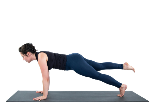 Woman practicing plank pose with one leg off the ground Woman practicing plank pose with one leg off the ground