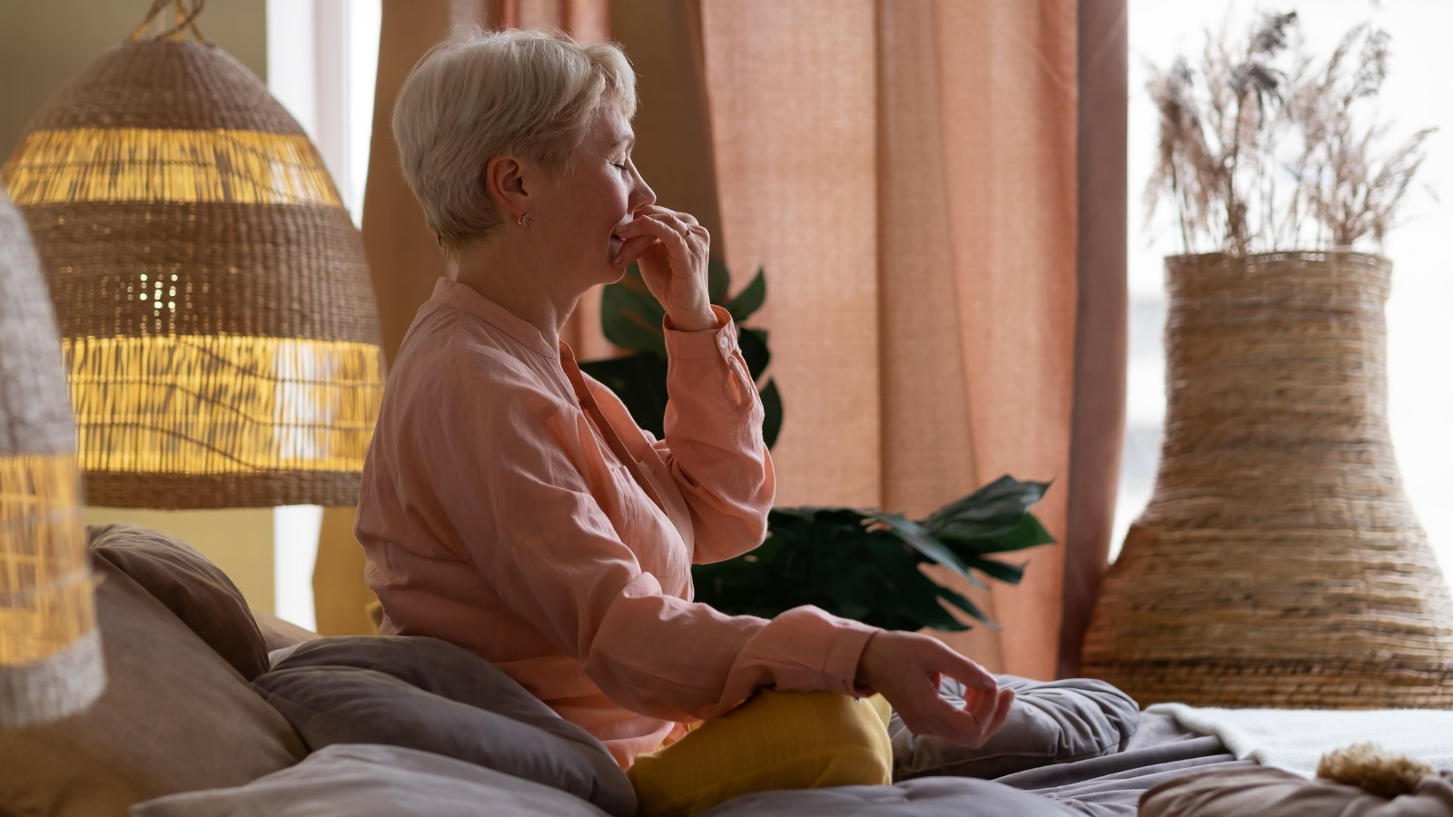 Senior woman practicing yoga's Alternate Nostril Breathing exercise, nadi shodhana pranayama pose