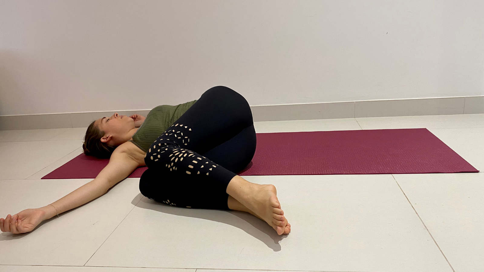 How to practicing twisting spine yoga poses in Revolved Belly Pose (Jathara Parivrttanasana) to ease back pain
