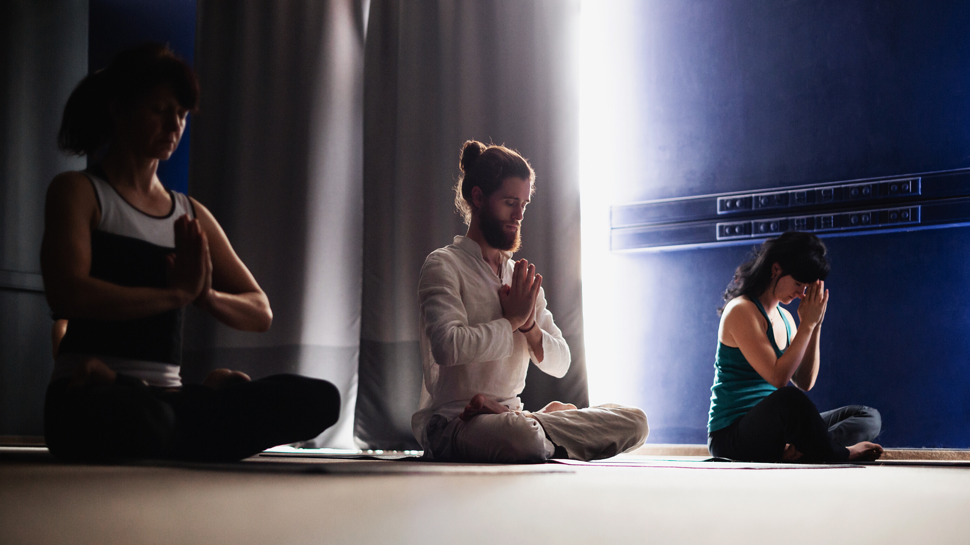 Group of yoga students practicing meditation in class.