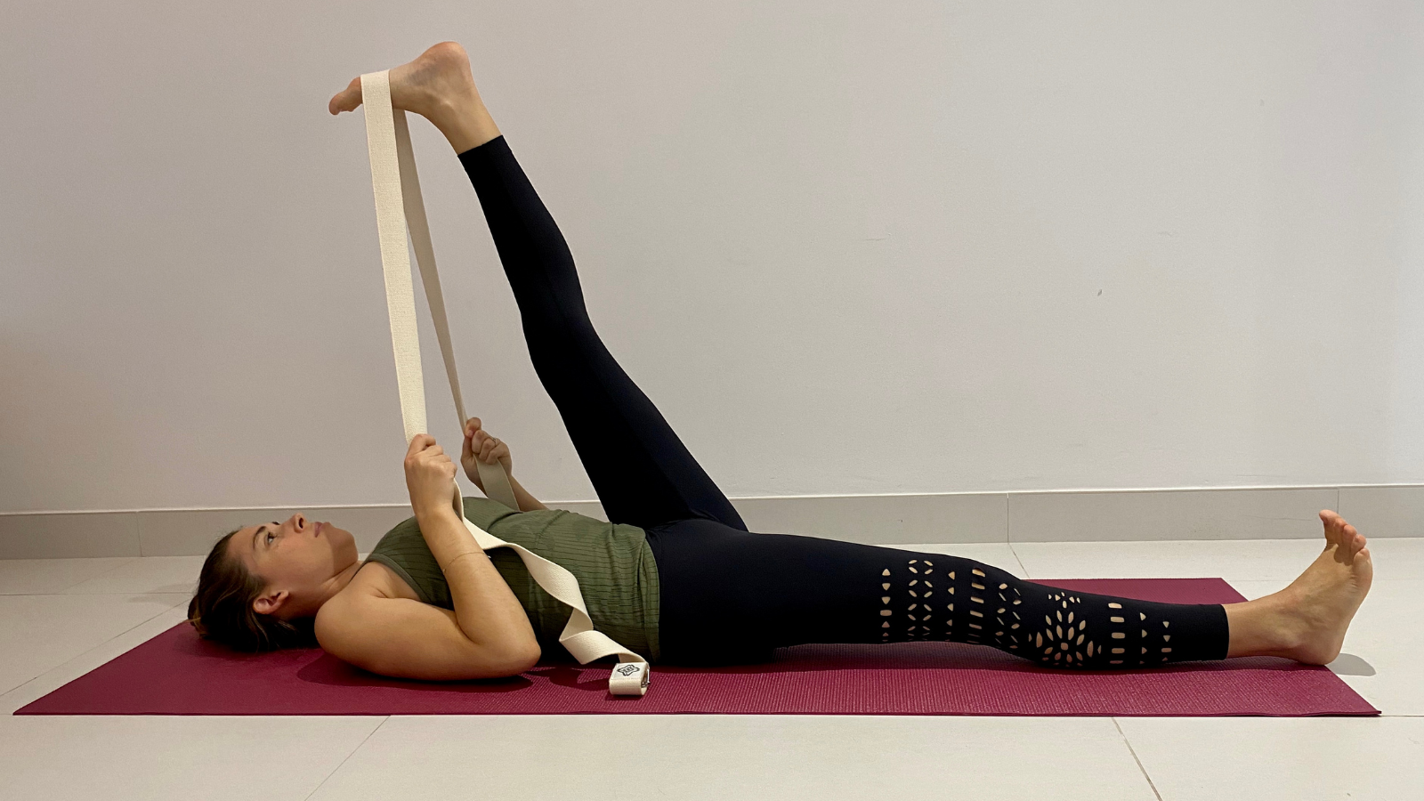 Yoga beginner tips to lengthen the hamstrings and relieve back pain in Reclined Big Toe Pose (Supta Padangusthasana)