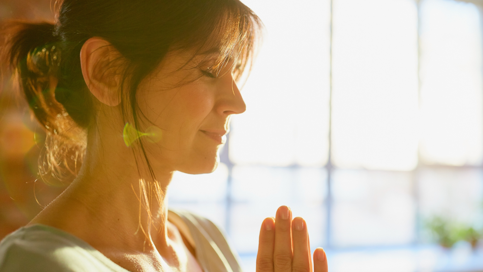 Meditation & reflection concept - close up of yogi woman meditating at yoga studio