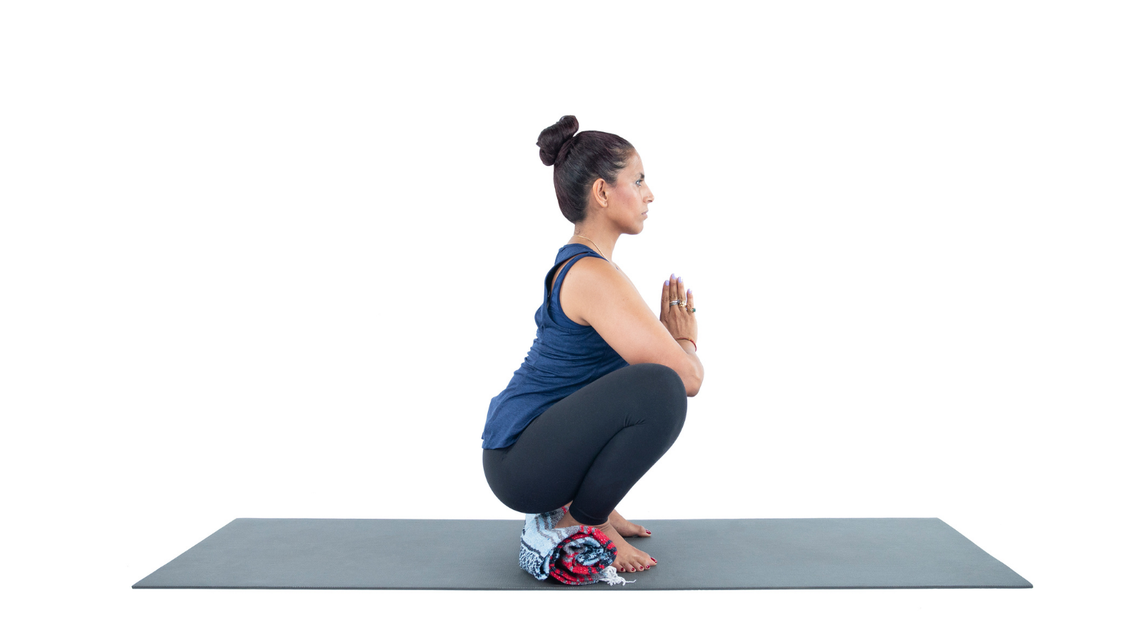 Yoga student practicing Yogic Squatting Pose (Malasana) for stronger pelvic floor and decreased urinary incontinence
