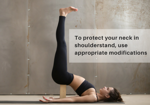 A woman in Shoulderstand (Salamba Sarvangasana) using a block under her lower back to help protect the neck
