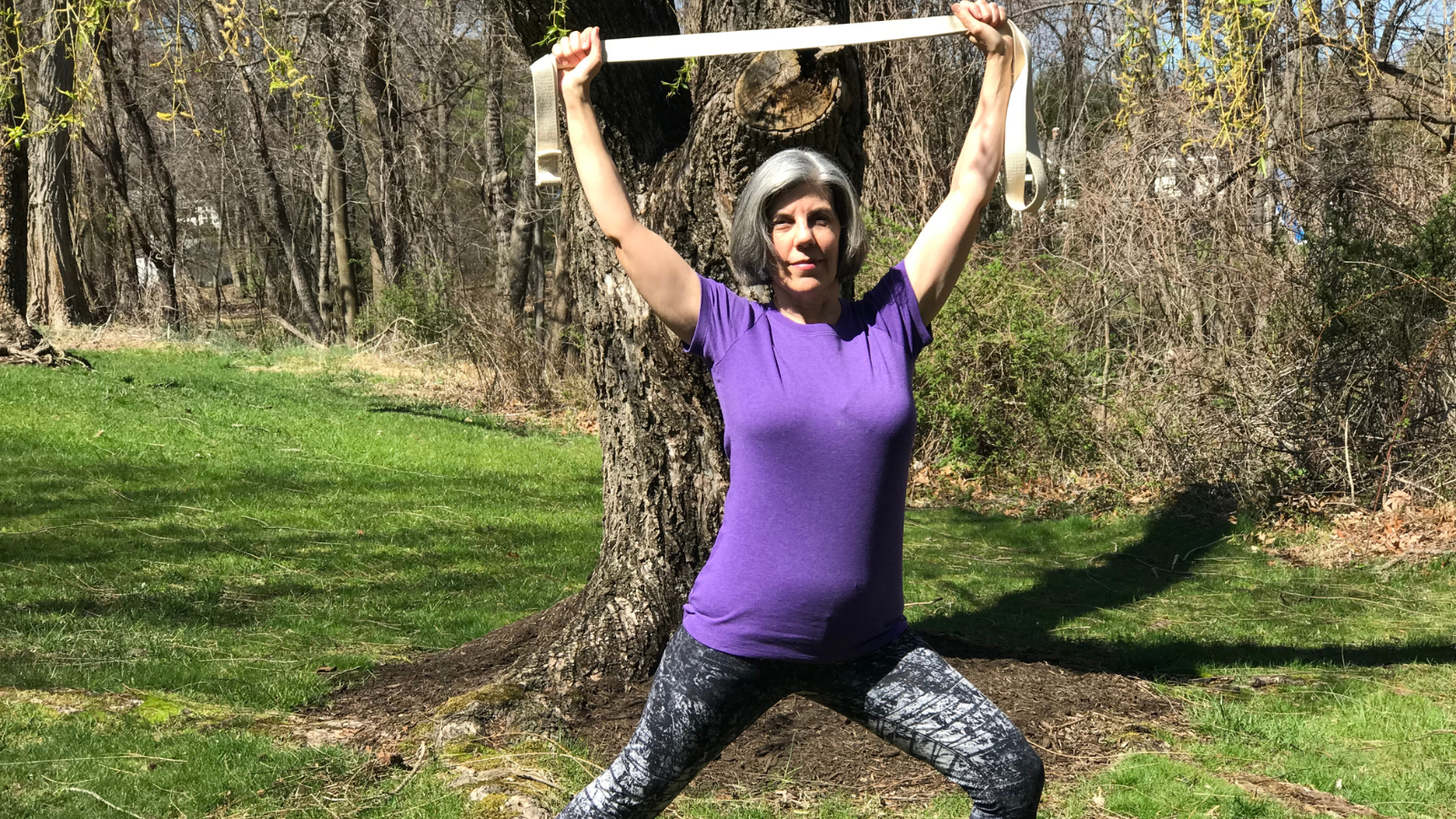 Adding a yoga strap to the practice of Warrior II Pose.
