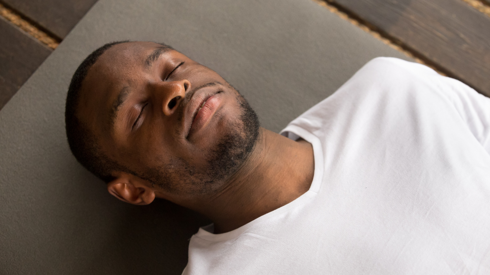 Photo of young black man lying in Corpse Pose or Savasana Pose