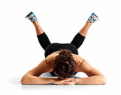 Woman practicing prone yoga pose to release the outer hips and open the external rotators with internal rotation