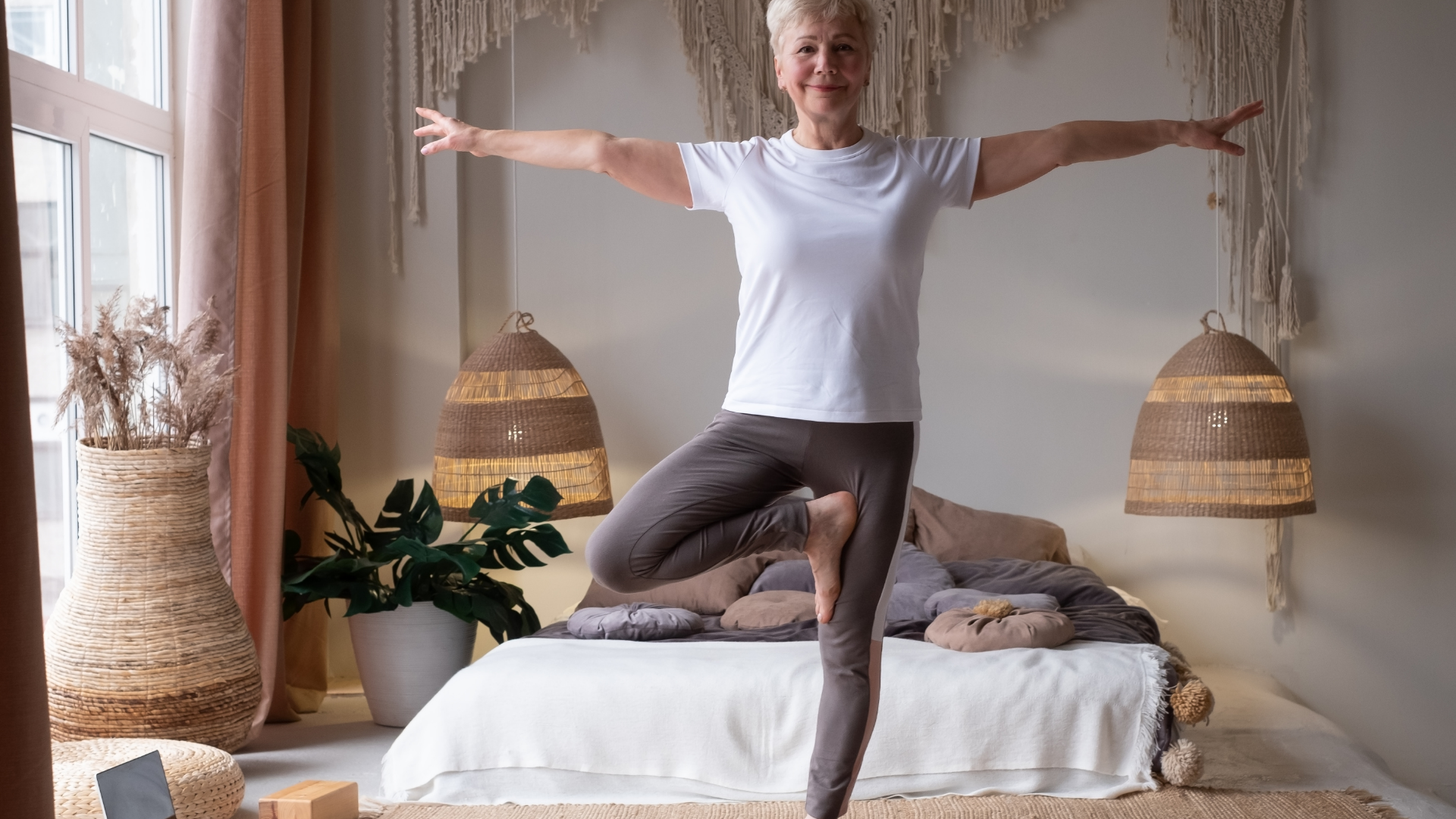 Full length portrait of senior woman in yoga pose Vrkshasana or Tree Pose