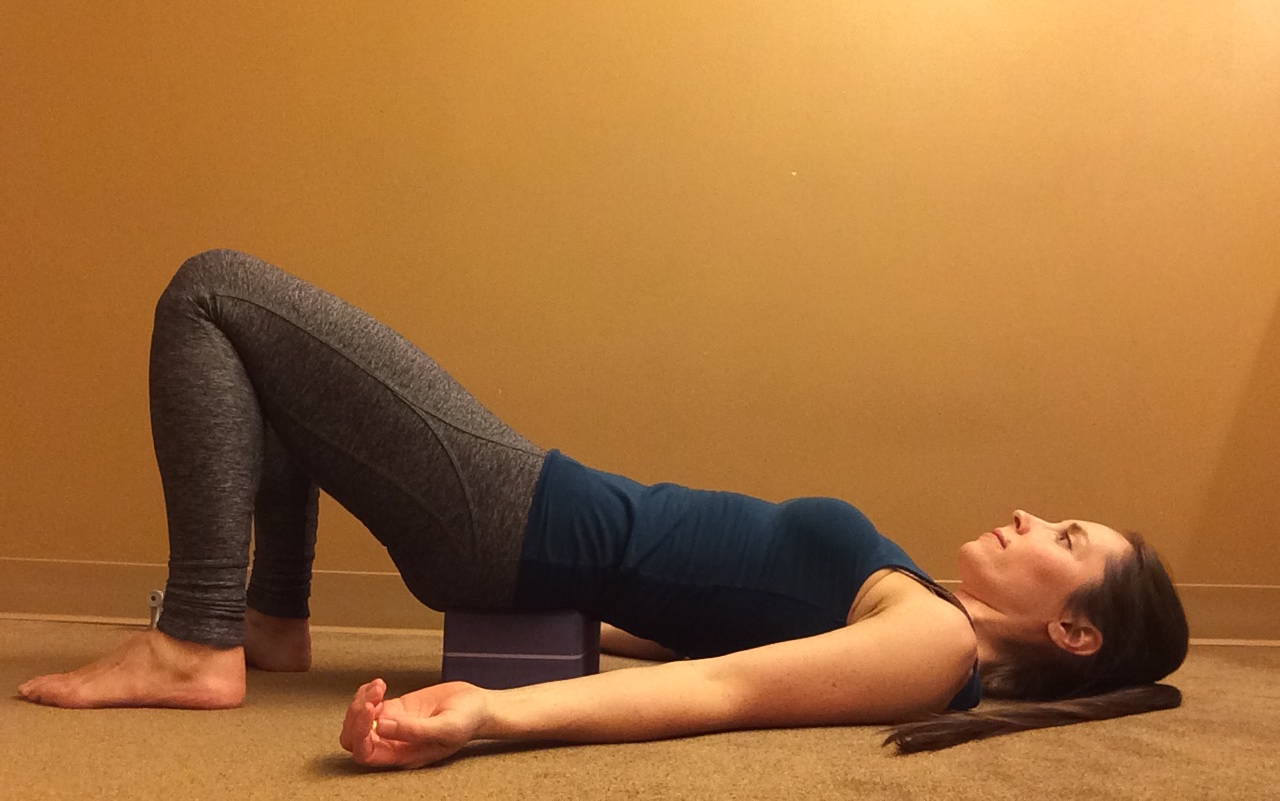 Supported Bridge Pose A woman in Supported Bridge (Salamba Setu Bandha Sarvangasana), a yoga pose to massage the psoas muscle