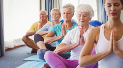 Group of older yoga students practicing to help the symptoms of rheumatoid arthritis