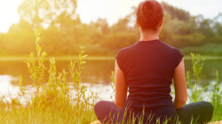 Young girl practices yoga on the shore of the River, concept of enjoying privacy, concentration