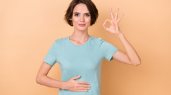 Photo of young lady arm on belly show fingers OK symbol good for a happy healthy gut.
