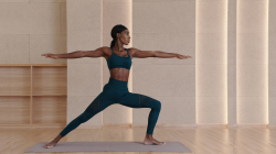 Black yoga teacher practicing Warrior II Pose (Virabhadrasana II)