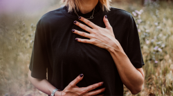 Woman holding her chest and abdomen.