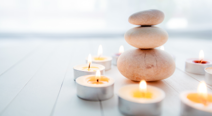 Zen Meditation Harmony, Spa Lifestyle, balanced stack of stones with aromatic candles on wooden whit