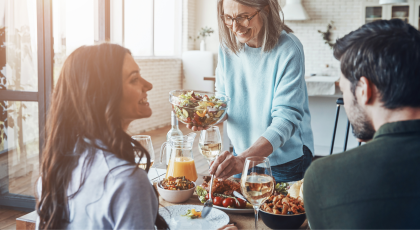 Happy family enjoying delicious dinner and smiling while sitting in the modern apartment