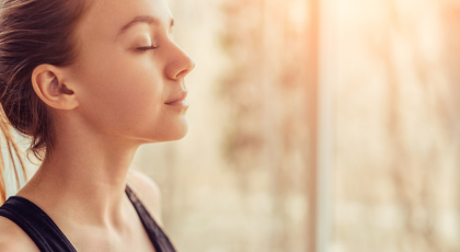 Side view offemale yoga student with closed eyes breathing while doing a breath practice during yoga