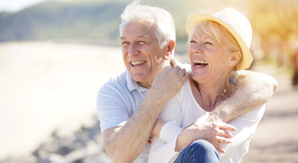 Senior couple relaxing by the sea on sunny day. 