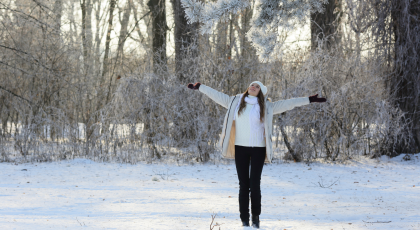 Smiling young woman with arms out to the side, representing feeling free