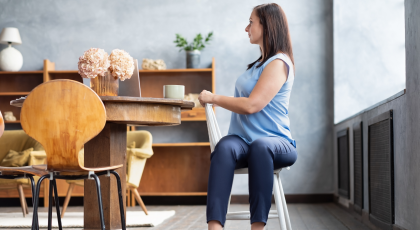 Female office worker in yoga pose Ardha Matsyendrasana or Half Lord of the Fishes Pose on a chair