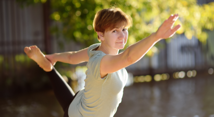 Older beginner yoga student practicing yoga outside to increase serotonin