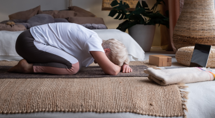  Senior woman doing forward bend yoga exercise Balasana, Child Pose