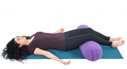Restorative Savasana with a bolster to support the legs