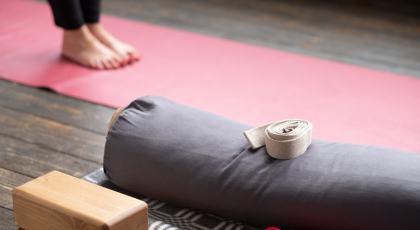 Female yoga student legs on yoga mat. Yoga props for Iyengar lesson