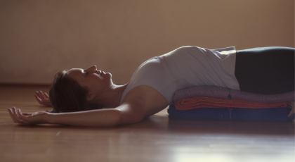 Woman practicing yoga for sleep in Fish Pose (Matsyasana)