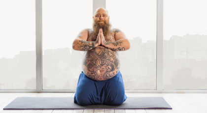 Tattooed man practicing yoga.