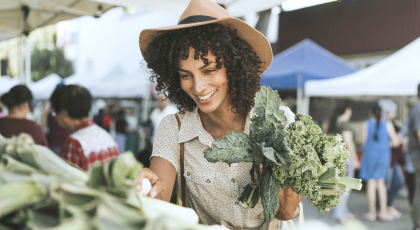 Yoga student buying vegetables at the farmers market.