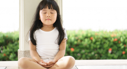 Young child practicing yoga meditation