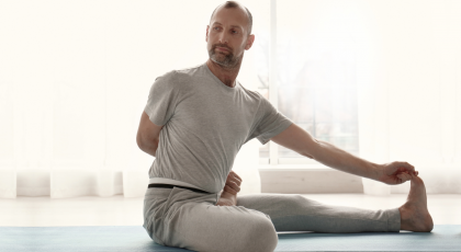 Man practicing yoga forward bend - janu sirsasana.