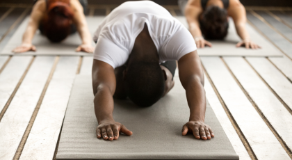 Male yoga student practicing balasana childs pose