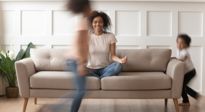 Woman practicing yoga meditation at home with kids.