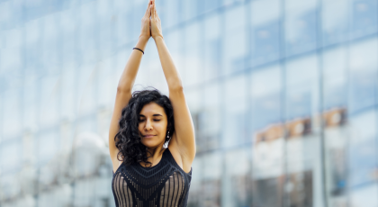 Woman practicing yoga outside hands in prayer. 