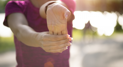 Woman practicing yoga wrist stretch. 