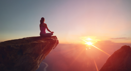Yoga student practices yoga principles for the new year and meditates on the mountain